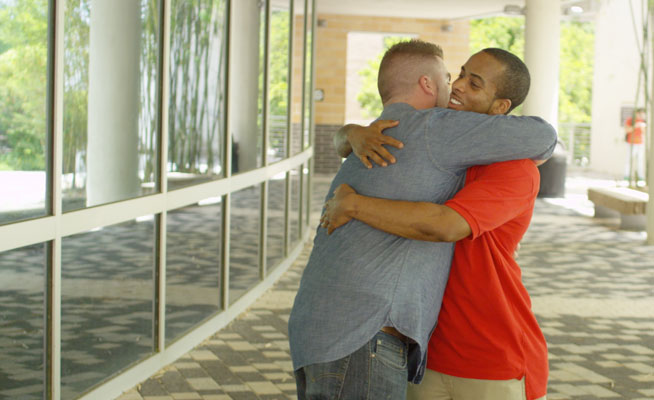 two men hugging for support