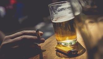 Smoking a cigarette at a bar with a beer and a lighter