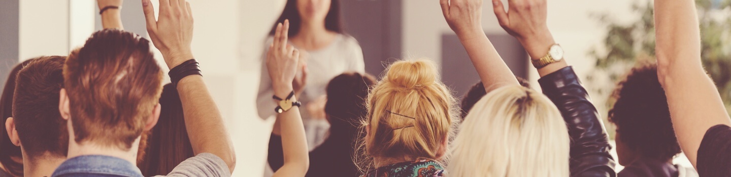 Classroom of students raising their hand