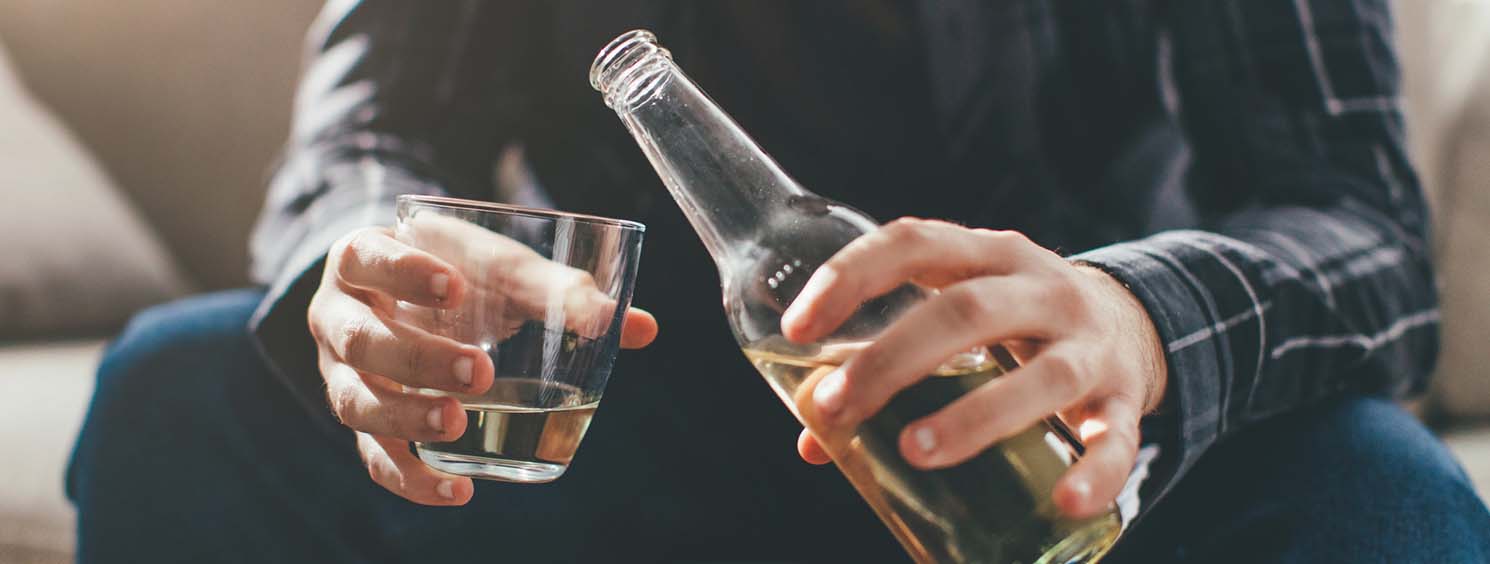 Person pouring alcohol in glass