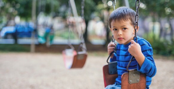 young boy swinging at the park