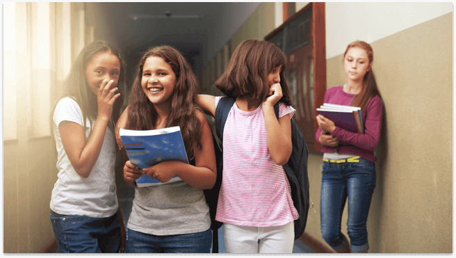 Group of girls laughing and bullying another girl