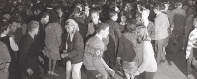 People dancing to music at a party in the 1950s