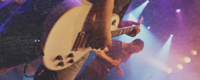 Musician playing an electric guitar on stage for a concert