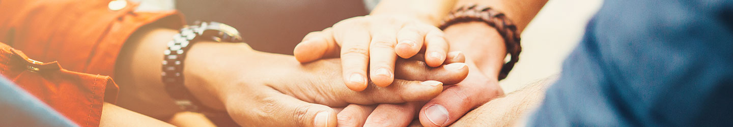 group of people with their hands in a circle