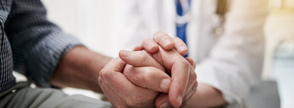 Two people holding hands, offering support