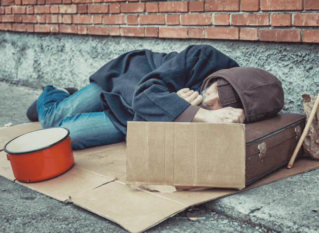 Homeless man sleeping on the sidewalk