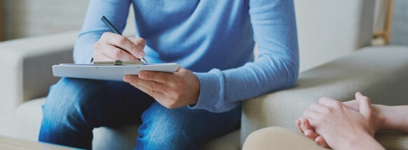 Professional having conversation with patient, taking notes