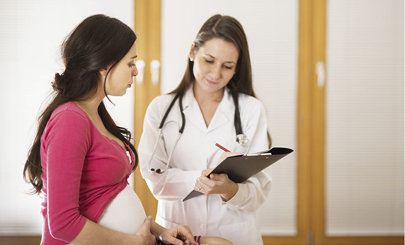 Pregnant woman consulting with her doctor