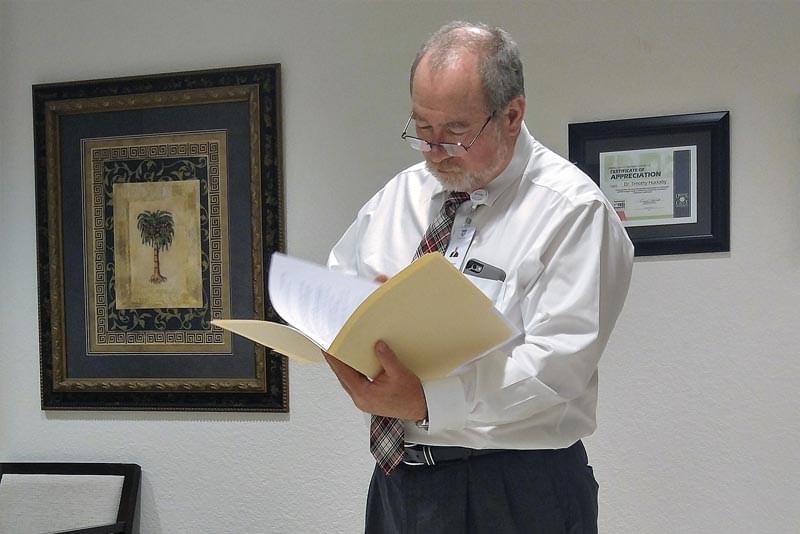 Dr. Huckaby reading over a patients chart at the Orlando Recovery Center
