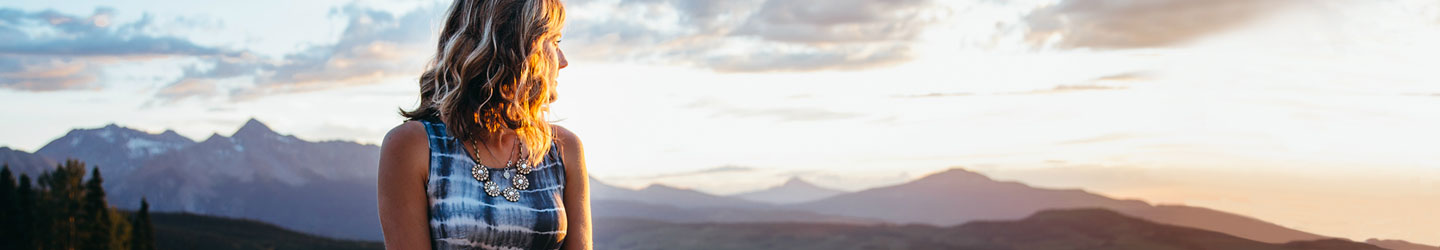 woman staring off into sunset in the mountains