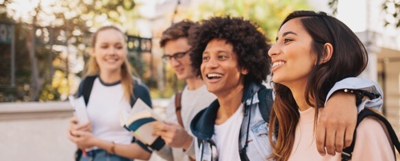 Teens walking outside and smiling outside.