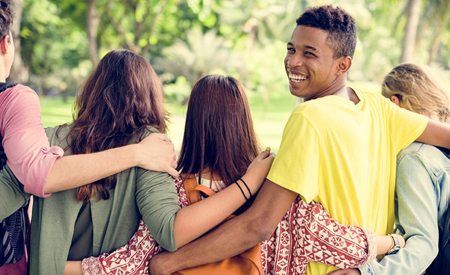 Diverse group of teenagers embracing each other
