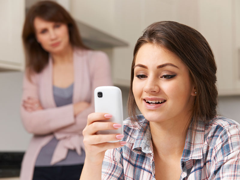 Concerned mother watching teenage daughter