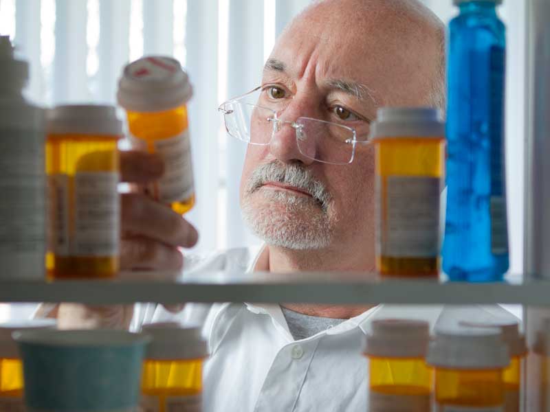 Senior man looking at prescription drugs