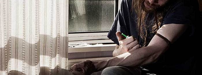 Man shooting up heroin with needle