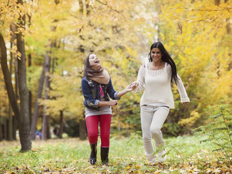 Mother and daughter are having fun in autum nature