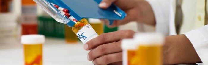 Pharmacist filling prescription bottle with opioid pills
