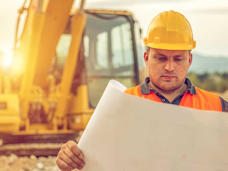 Construction worker holding blueprints