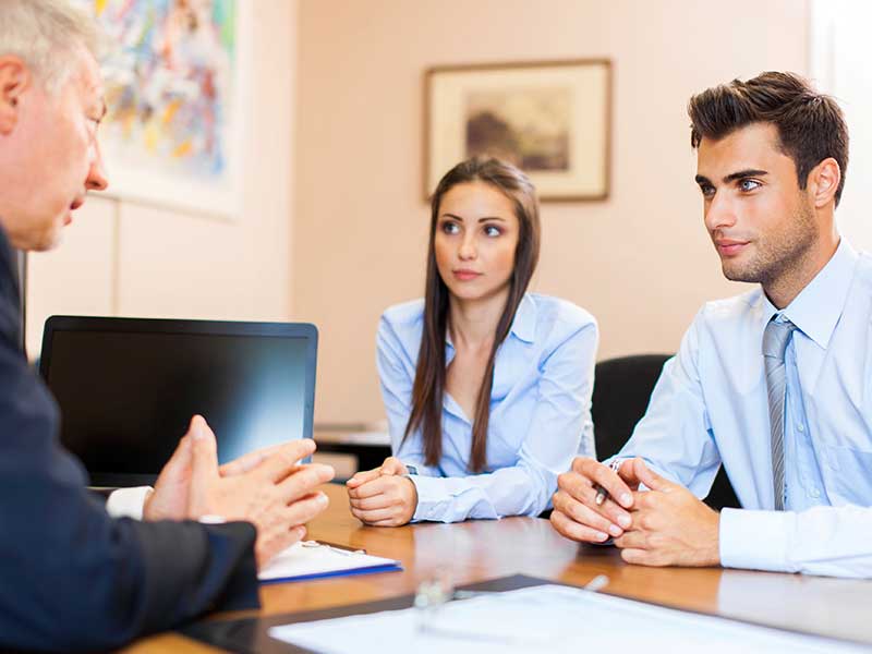 Young man and women speaking with boss