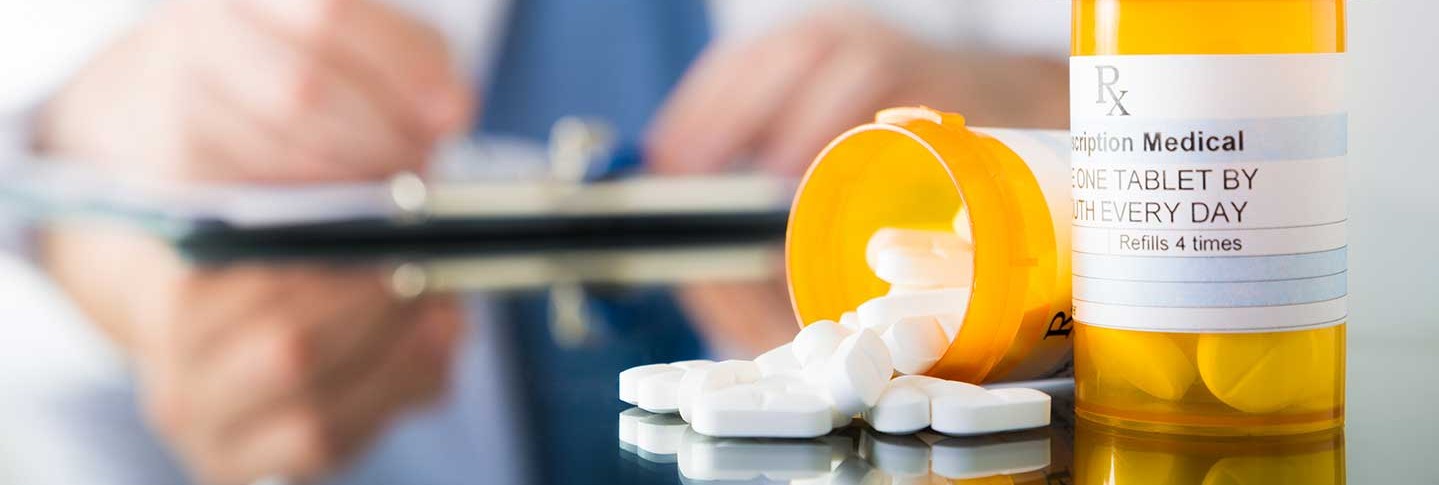Prescription amphetamines spilling out of a pill bottle on a table