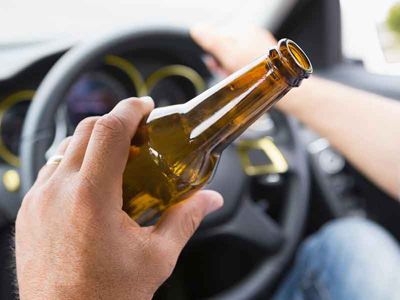 Man drinking beer while driving