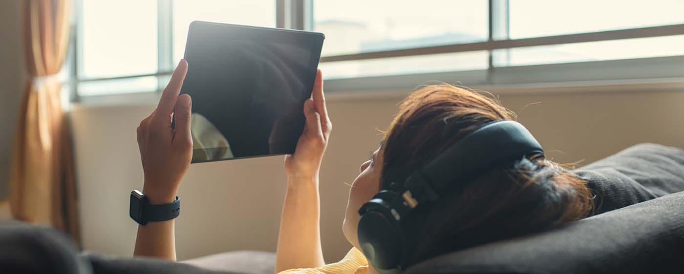 Woman looking at digital tablet and listening to headphones